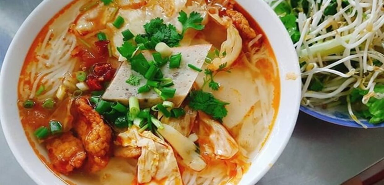 A clear, light Vietnamese fish broth with tomato and pineapple in a bowl