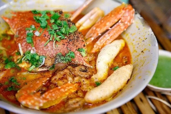 Bánh canh ghẹ — thick orange crab broth with a whole crab and chewy noodles