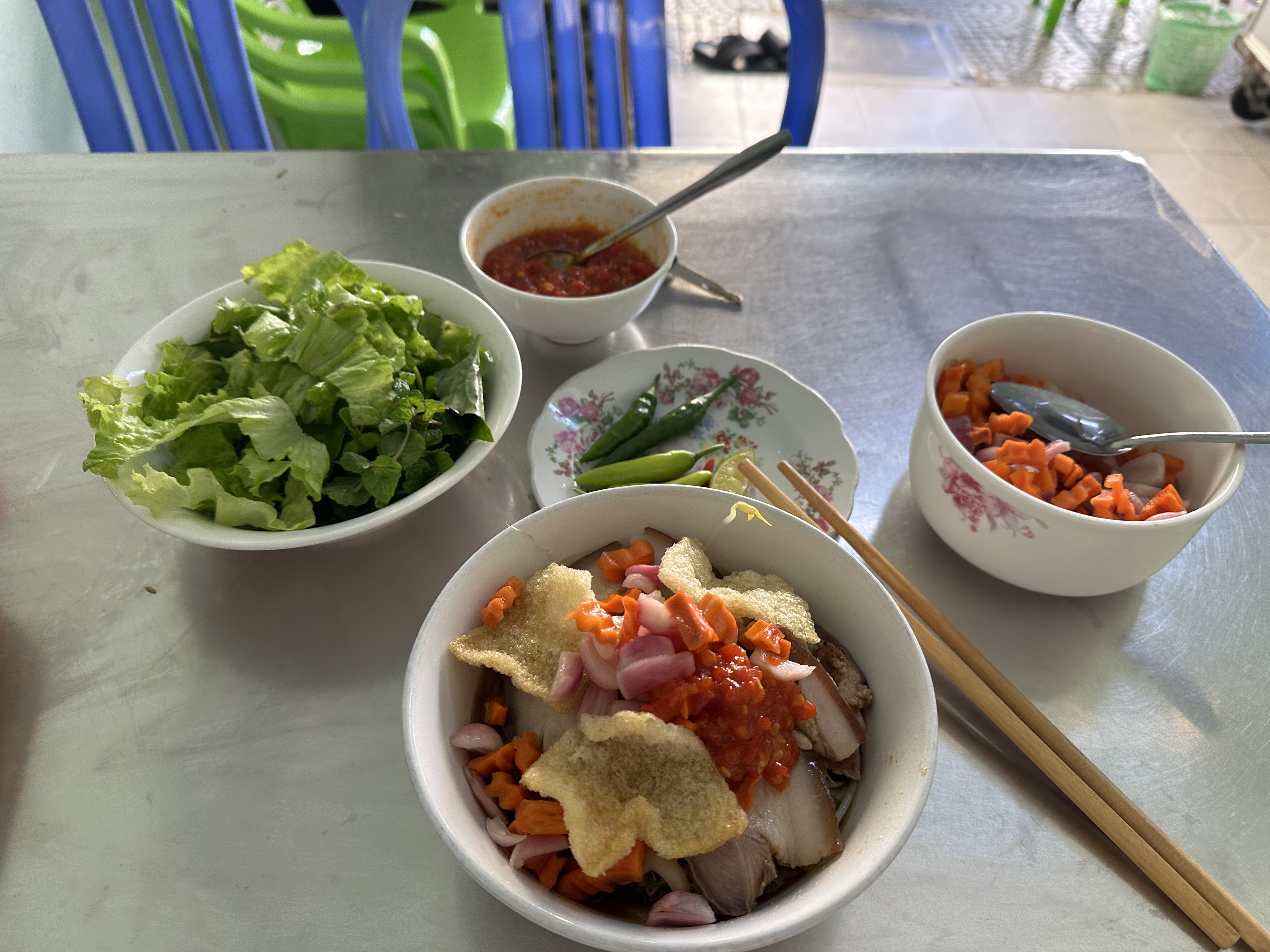 Close-up of cao lầu showing the firm pale-brown noodles, char siu pork and crunchy fried squares