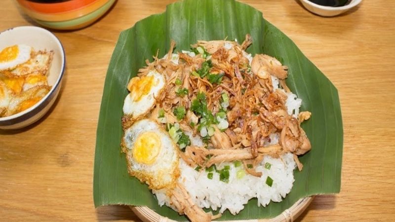 Xôi gà: sticky rice with shredded chicken and crispy fried shallots in a takeaway box