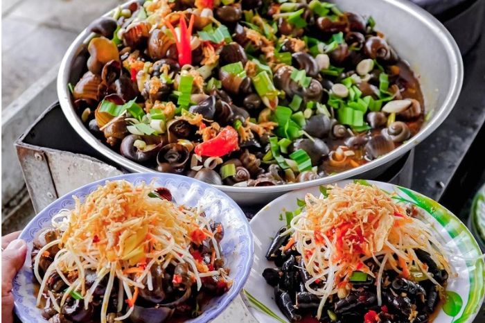 A portion of ốc hút served with grilled rice paper and a bowl of chili-ginger dipping sauce