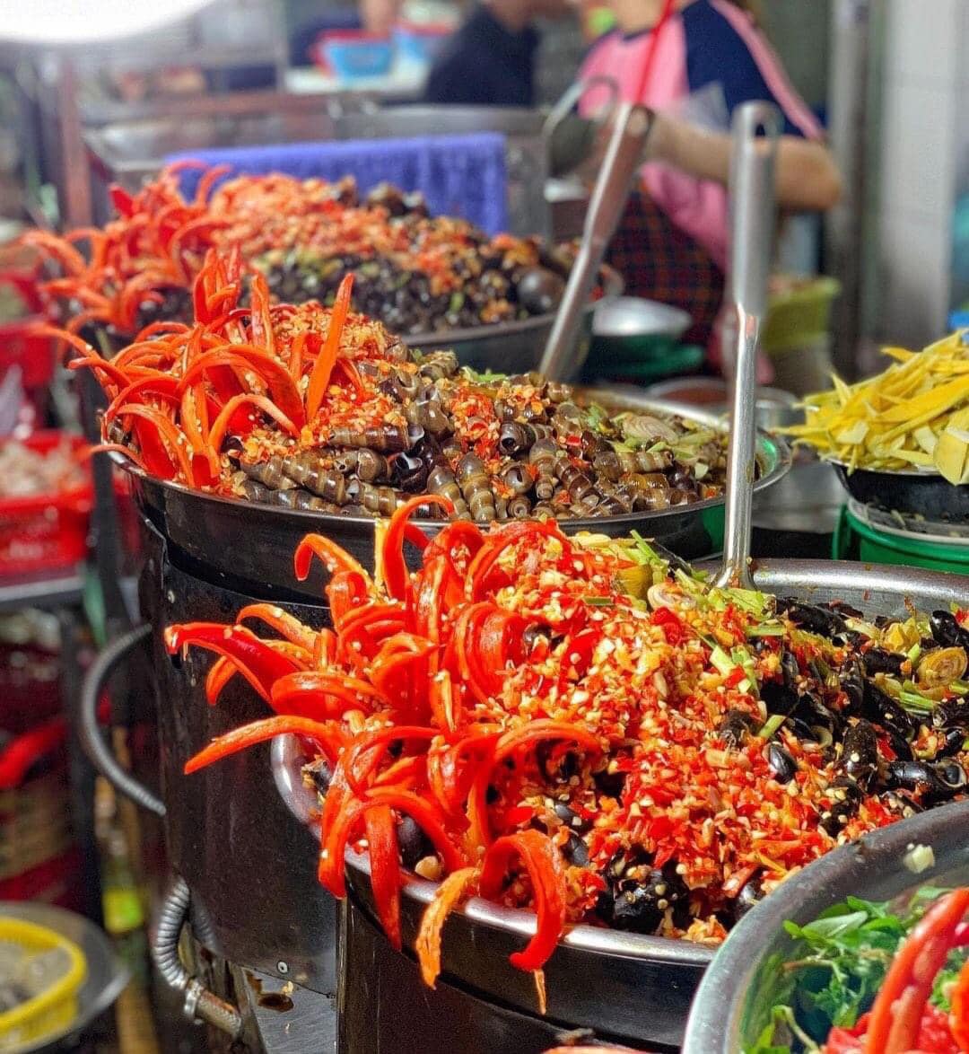 An evening street-food stall in Da Nang with low plastic stools where locals gather for snails and beer