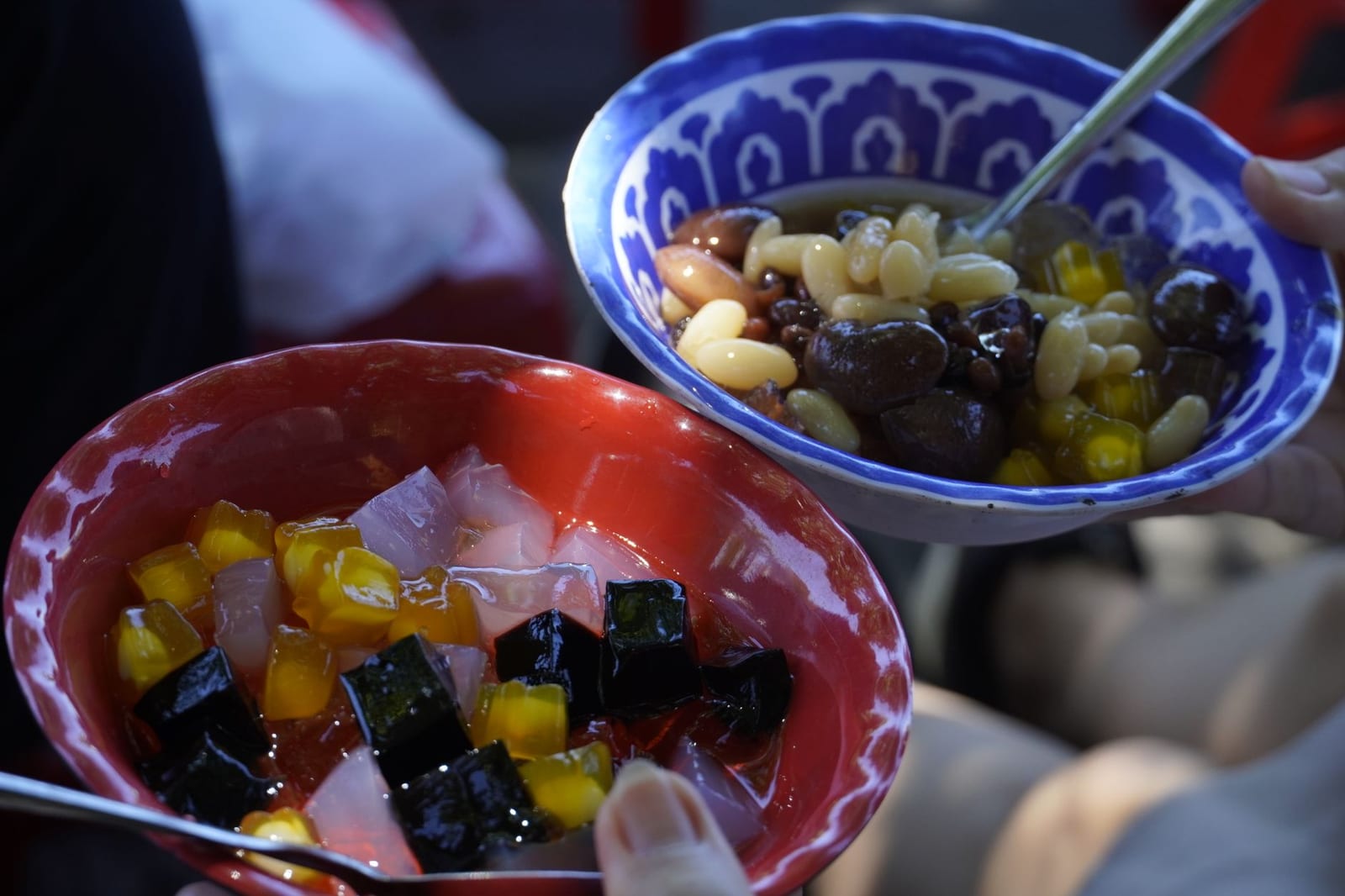 A glass of Vietnamese chè with layers of jelly, beans and crushed ice at a Da Nang dessert stall
