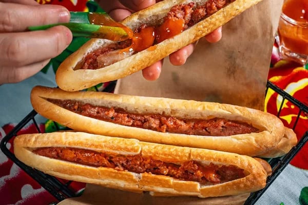 Crispy bánh mì que sticks with chili sauce added, served fresh from the stall.
