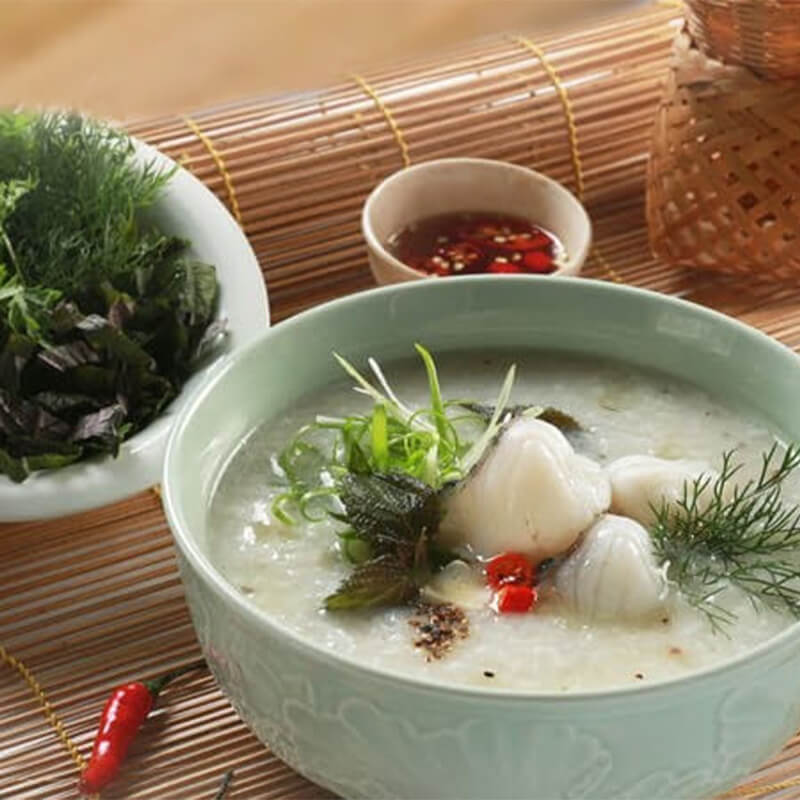 A plate of crunchy fried dough sticks (quẩy) with dipping sauce, served alongside Vietnamese rice porridge