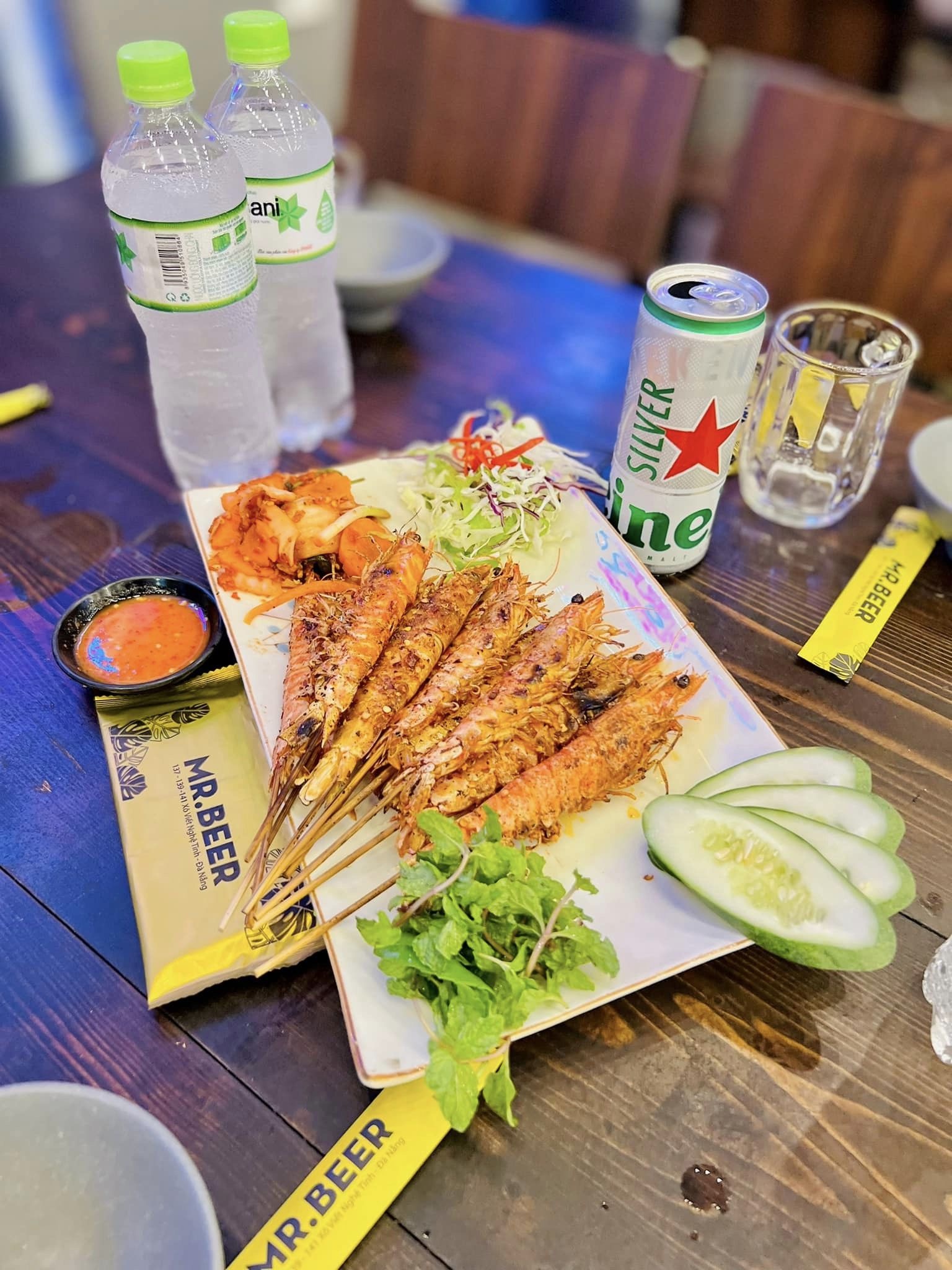 Grilled tiger prawns with a Heineken Silver and a glass of beer over ice at a Da Nang nhậu spot.