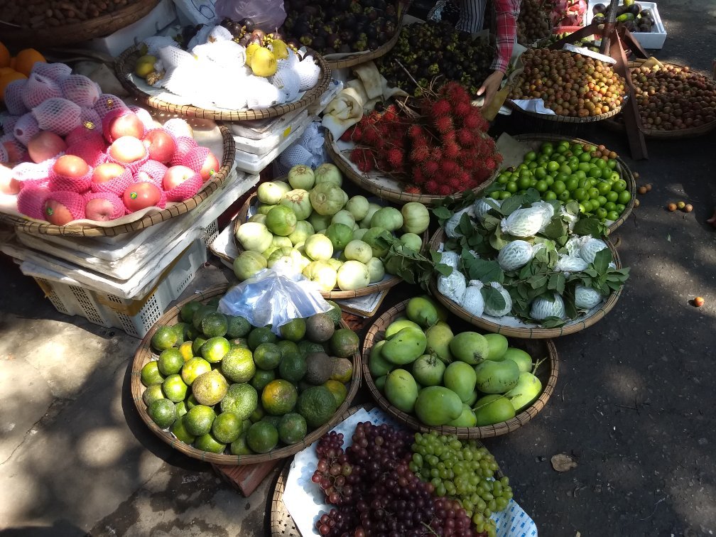 Fruit stalls at Bắc Mỹ An Market, Ngũ Hành Sơn — fresh tropical fruit piled high at a local Da Nang wet market.