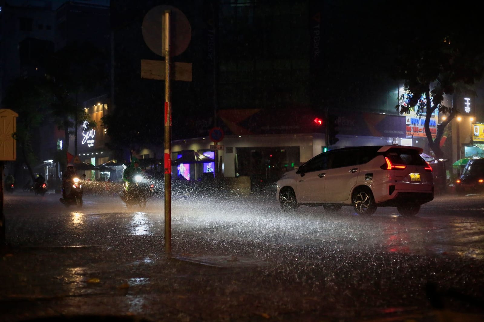 A sudden rainy-season downpour on a Vietnamese city street