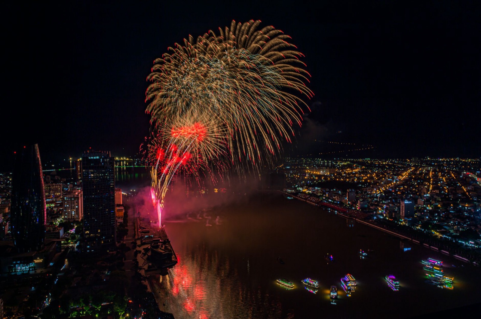 Red fireworks bursting over the Han River during the Da Nang International Fireworks Festival